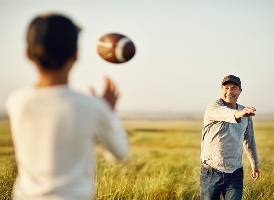 man throwing football to boy