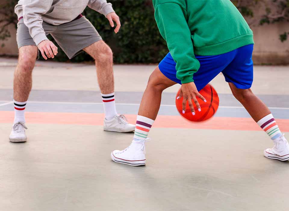 close up of legs of two men playing basketball