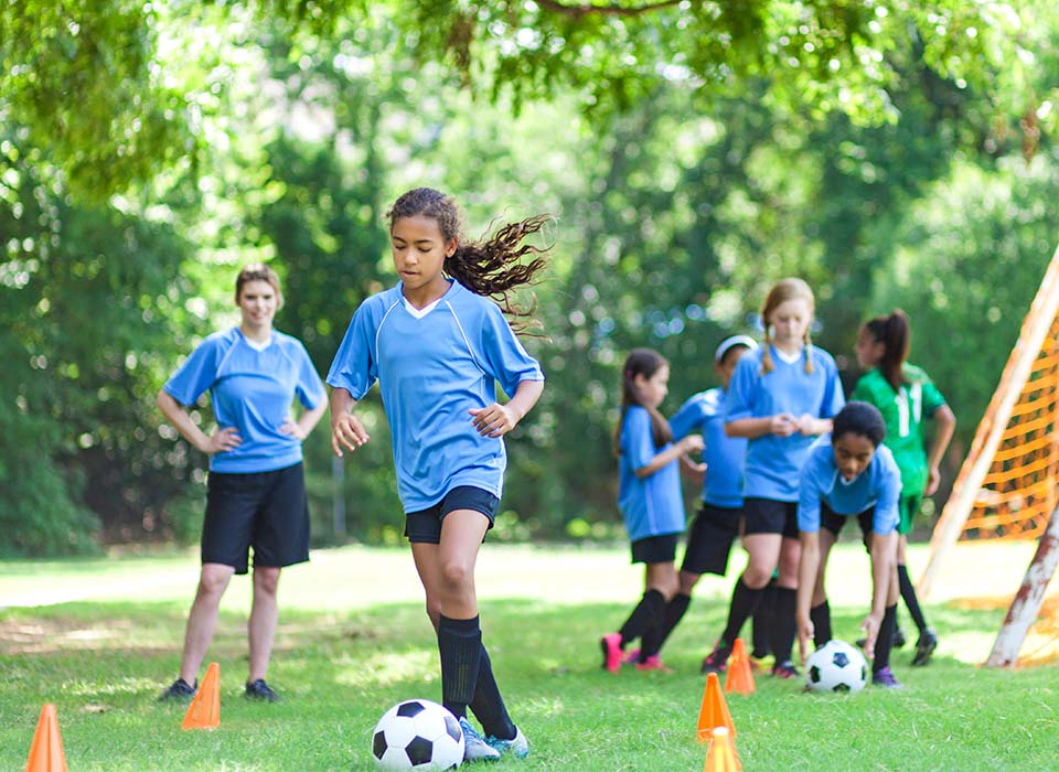 young soccer players run drills on a field