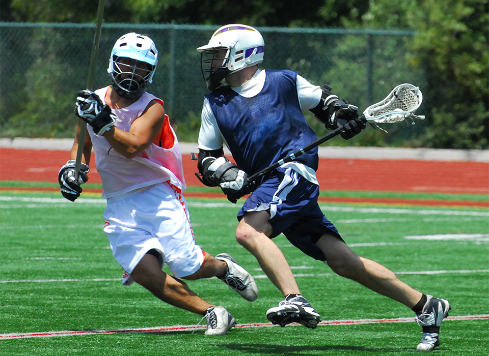 two lacrosse players in pennies practicing on a field