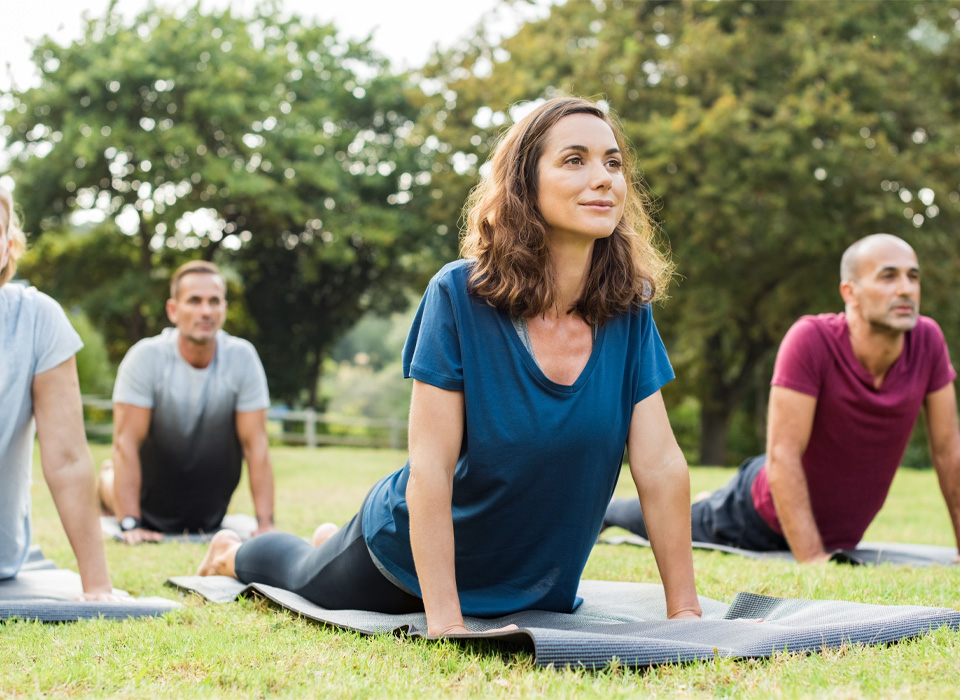 people laying on their stomach on yoga mats, pushing up with their arms