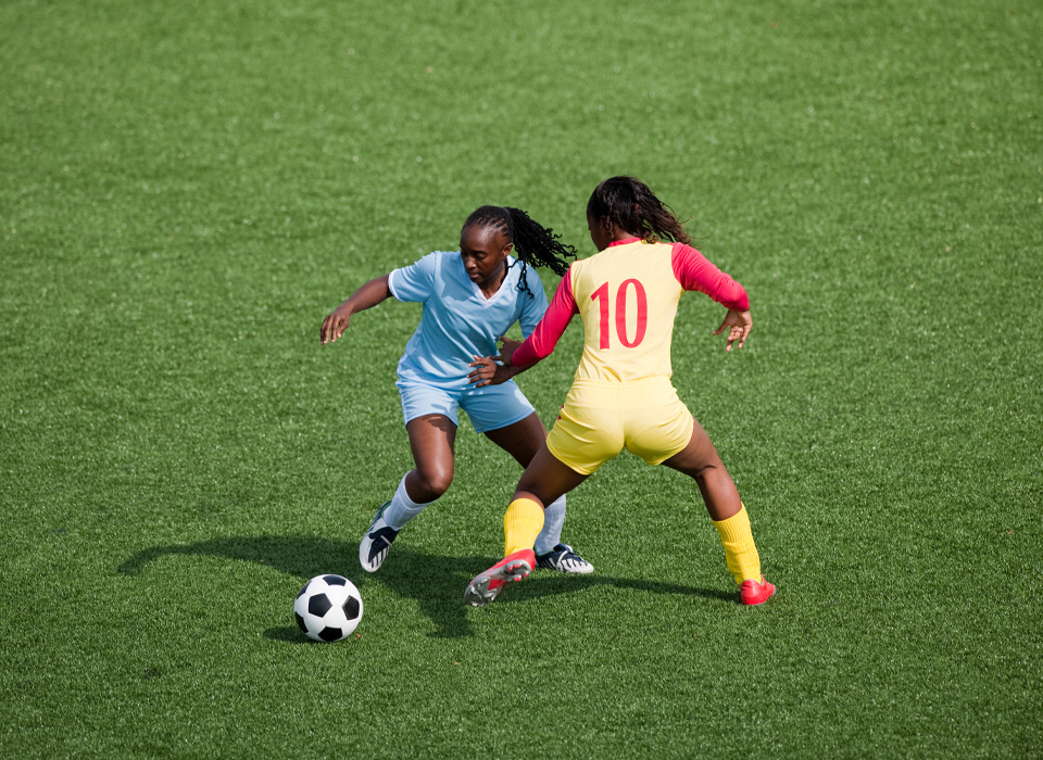 two soccer players fighting for the ball during a game