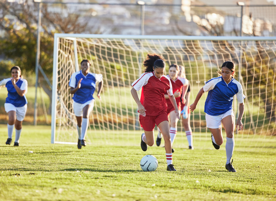 soccer players running after the ball in a soccer game