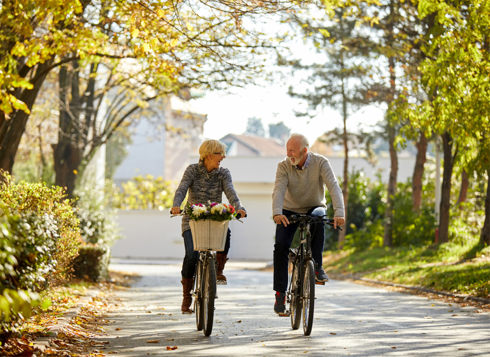 a man and a woman bike along a park path