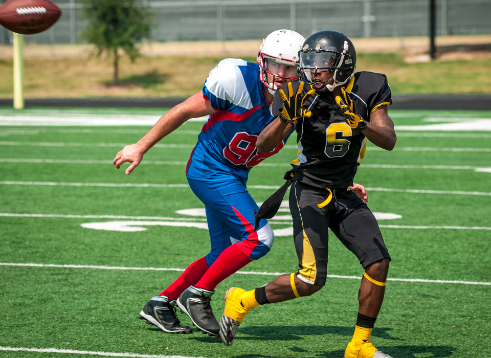 two football players are about to catch a football