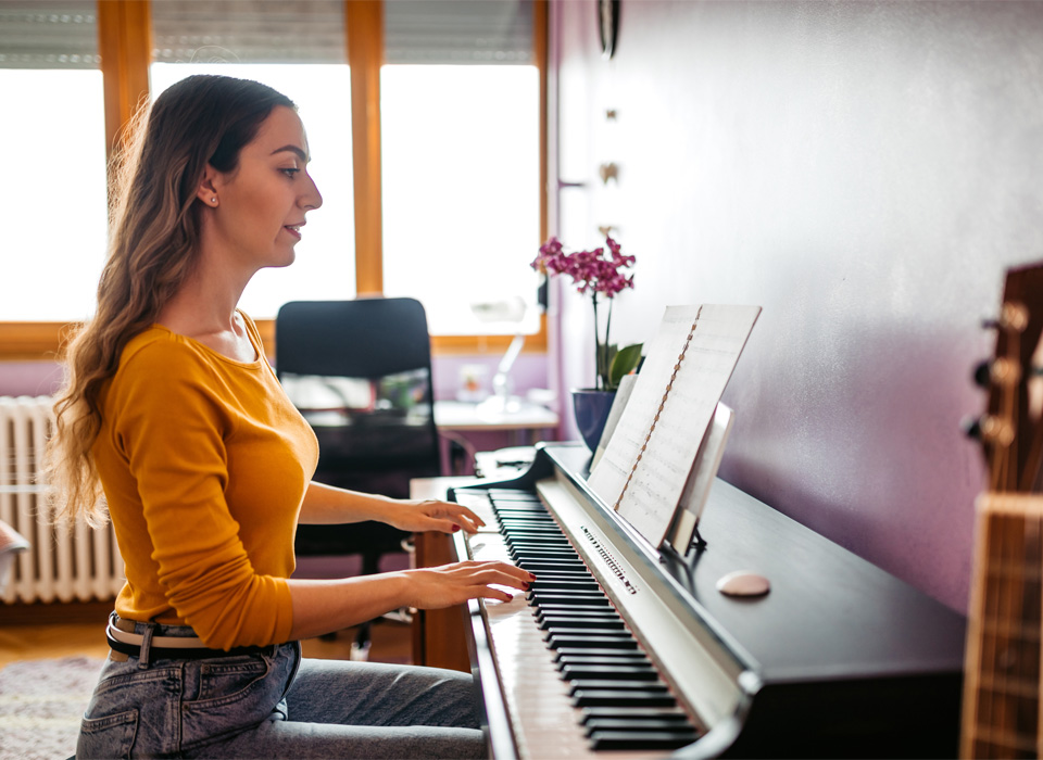 a woman plays an electric piano in her home