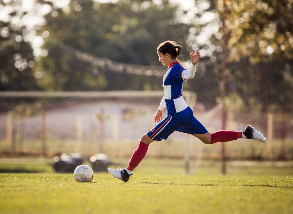 a soccer player kicks a soccer ball
