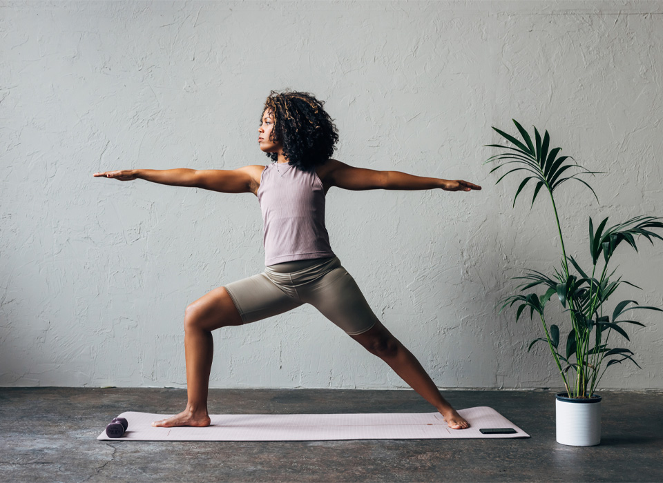 a woman does a yoga pose on a yoga mat