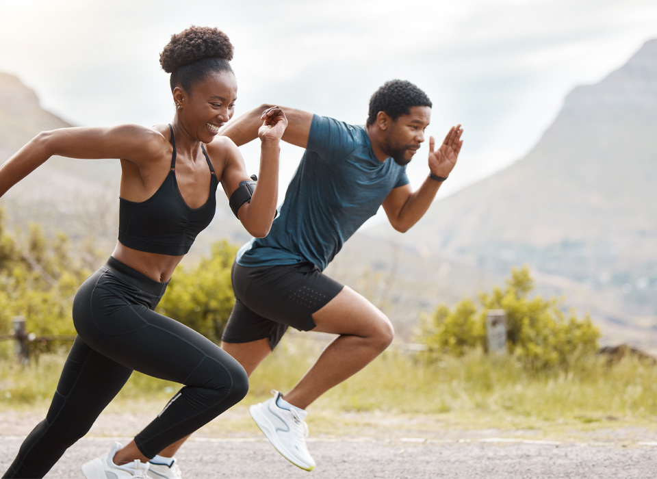 a man and a woman sprint in a race outside in the mountains