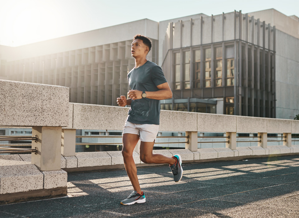 a man runs on a bridge in an urban setting outdoors