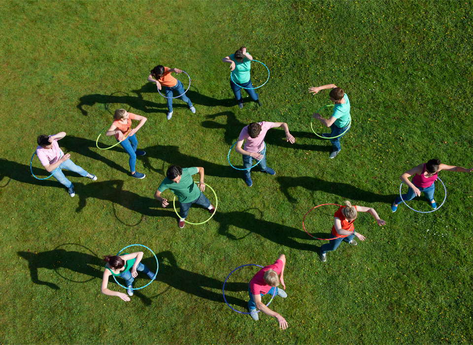 a group of people hula hooping are seen from above