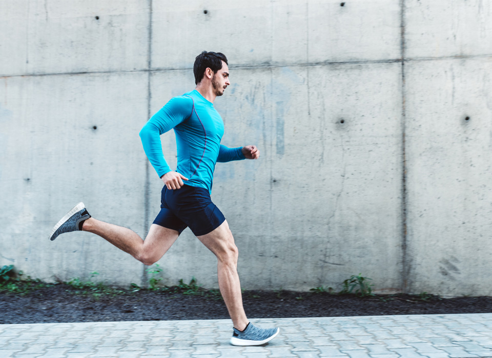 a man runs outside along a sidewalk