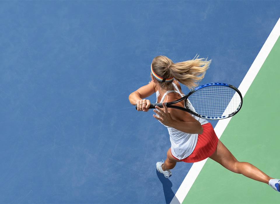 a tennis player in motion, about to swing her racket