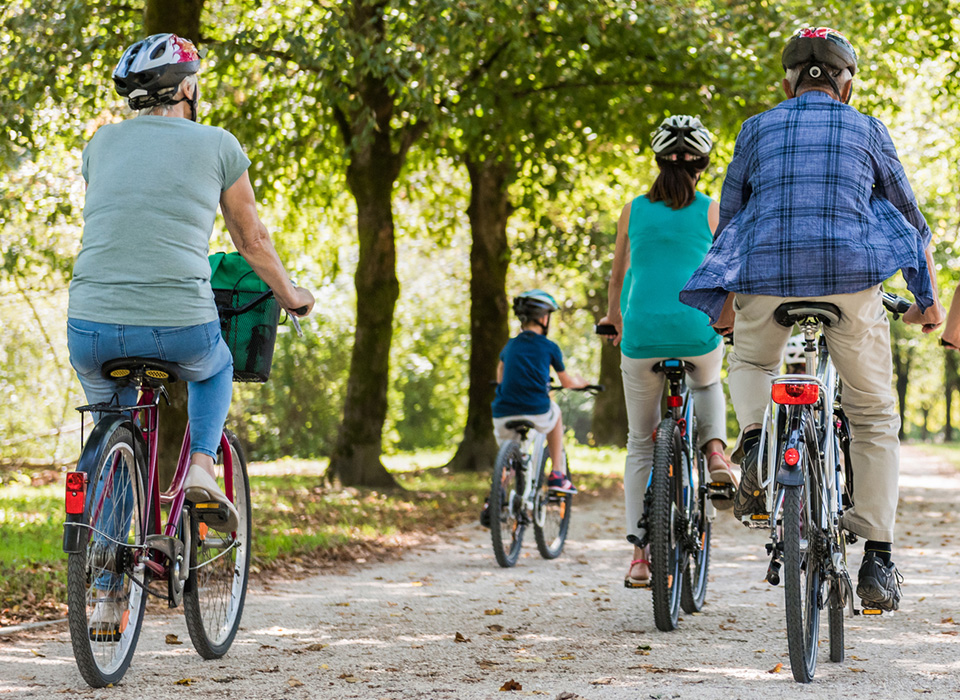 adults and children biking away from the camera on a nice spring day